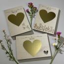 Holz‑Rubbelkarte zur Schwangerschaftsverkündung mit goldenem Rubbelherz.